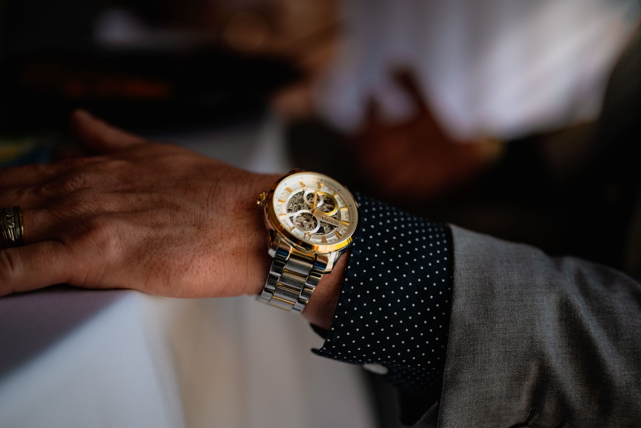 Close-up of a gold luxury wristwatch on a man's wrist, showcasing sophistication.